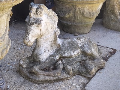 Lot 446 - A pair of cast concrete horses depicted lying...