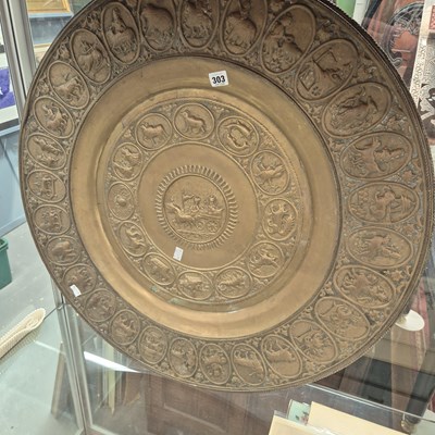Lot 303 - An eastern embossed brass calendar and deities...