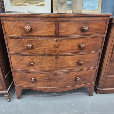 Lot 24 - A 19th century mahogany bow front chest of two...
